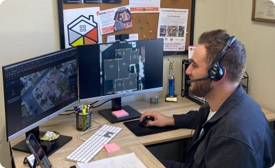 "A professional using dual monitors to plan a roofing project at Epic Roof Replacement in San Leandro, showcasing detailed satellite imagery and diagrams."